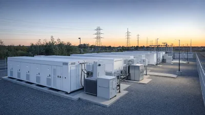 Energy shifting battery containers installed at a utility scale battery storage facility with step-up transformers