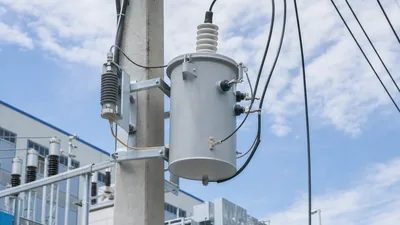 Single phase distribution transformer mounted on an overhead utility pole with primary and secondary bushings