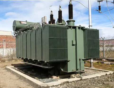 Oil-immersed power transformer positioned on a concrete plinth at the substation